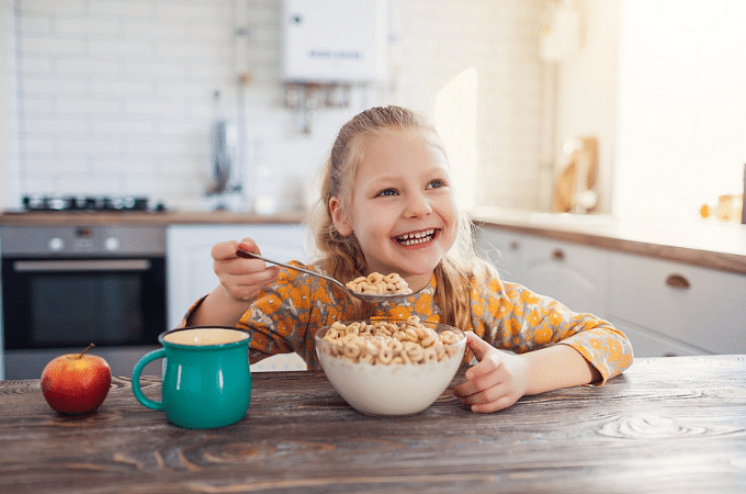 child eating cereal and smiling